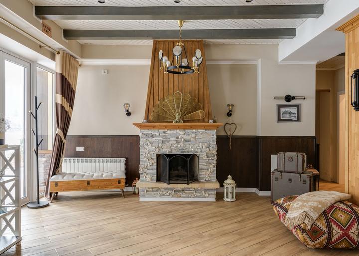 Rustic fireplace and wood beams in a bright sitting room
